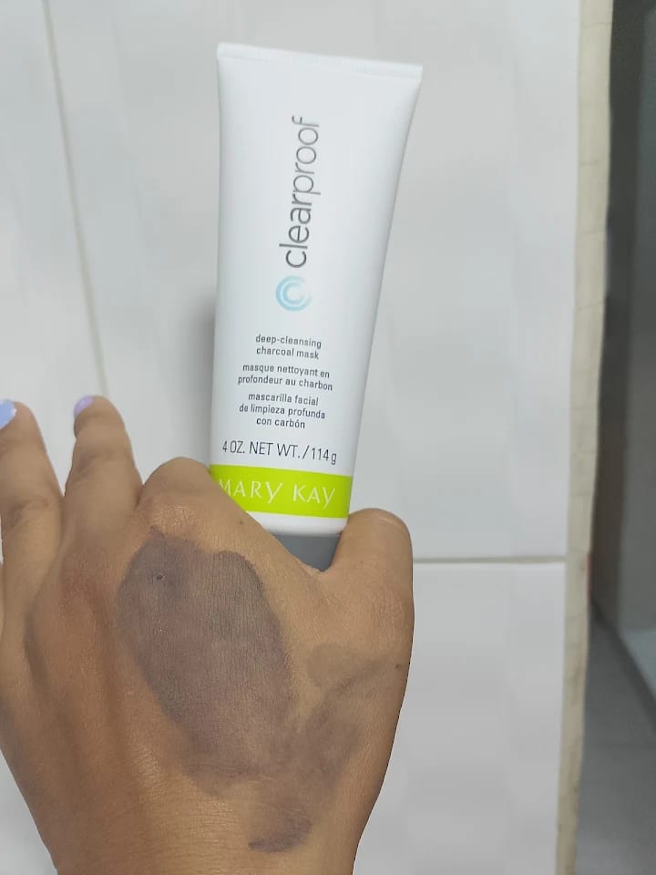 Prueba real de la mascarilla de carbón Clear Proof Mary Kay aplicada sobre el dorso de la mano junto al tubo de 114 g